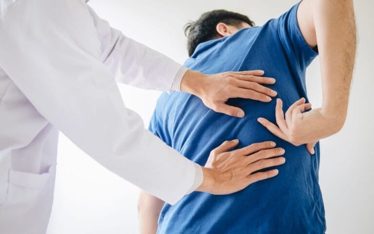 doctor examining man with back pain